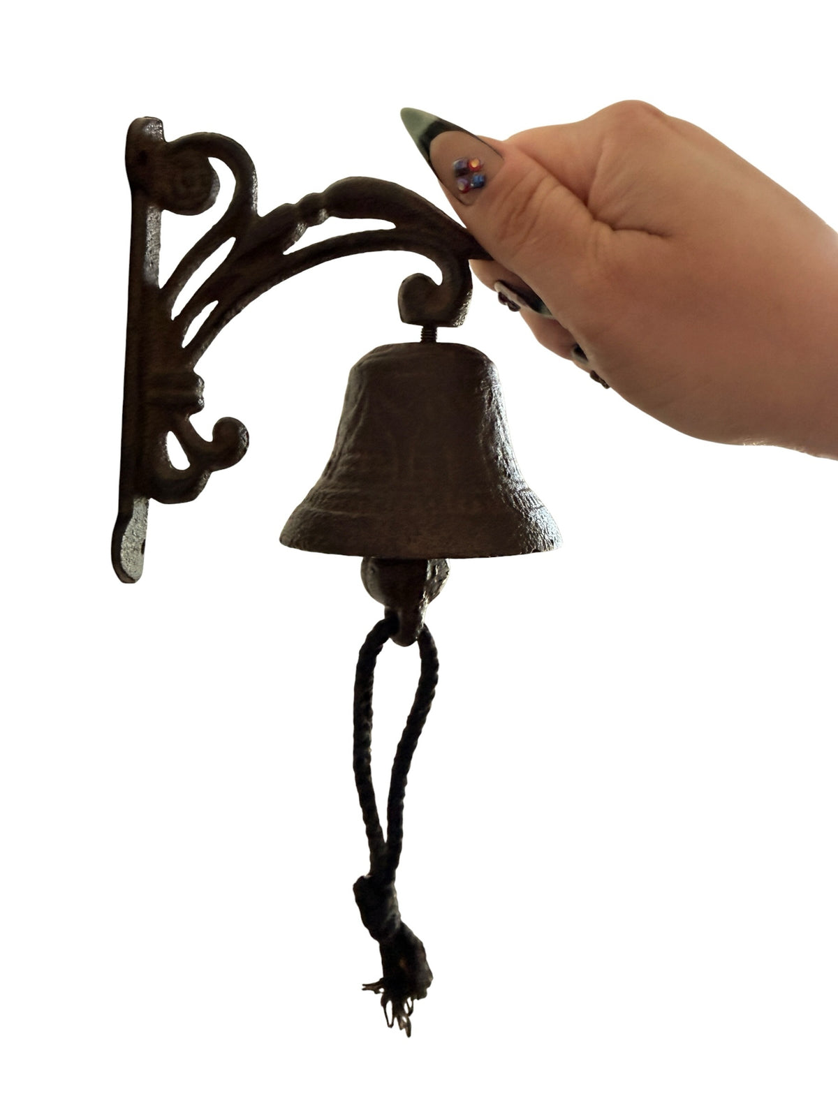 Chica Mexico cast iron wall-mounted bell with ornate scrolled bracket and rope pull being rung by a hand